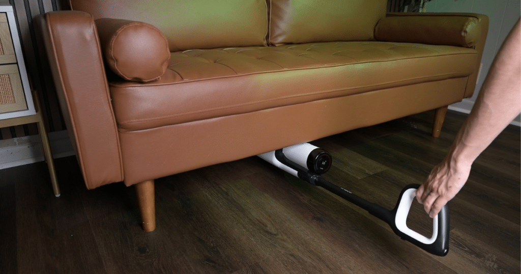 Tineco Floor ONE Stretch 6 wet dry vacuum lay flat design at Vacuum Wars | Vacuum Wars Tineco Floor ONE Stretch S6 lying flat to clean under a low sofa during hard floor cleaning.