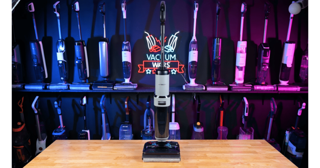 Tineco Floor One i5 Stretch Hard Floor Cleaner Vac Mop Combo at Vacuum Wars | Vacuum Wars Tineco Floor One i5 Stretch standing upright in the Vacuum Wars studio with other floor cleaners displayed in the background.