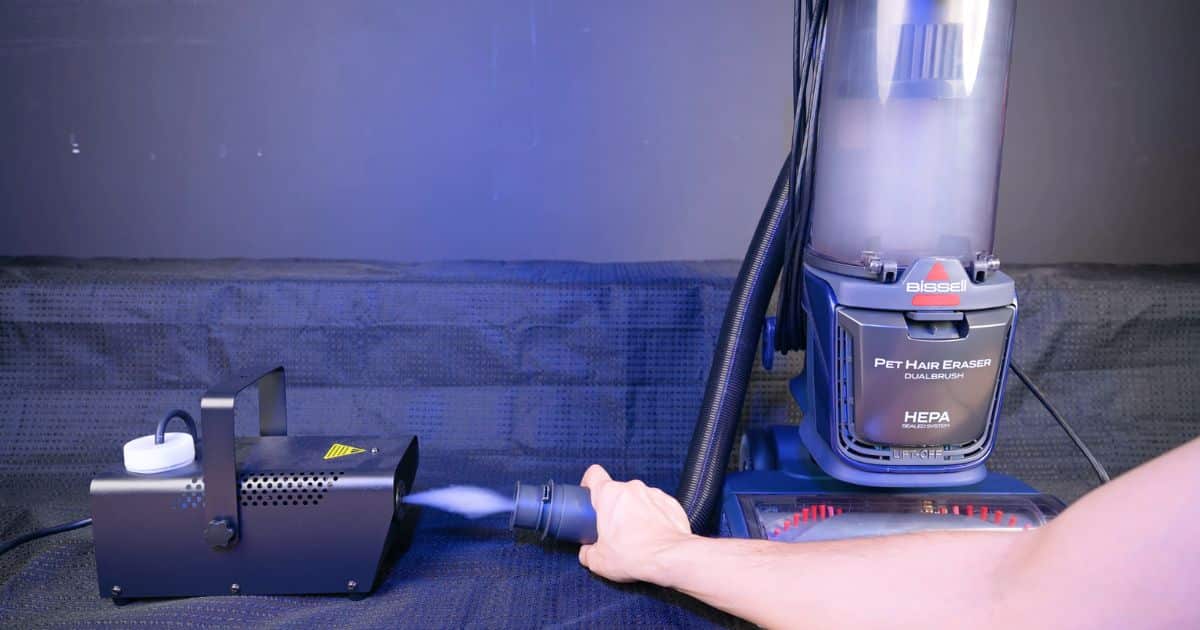 | Vacuum Wars Bissell Pet Hair Eraser DualBrush connected to a fog machine during a sealed filtration test, with no visible fog escaping from the vacuum body.