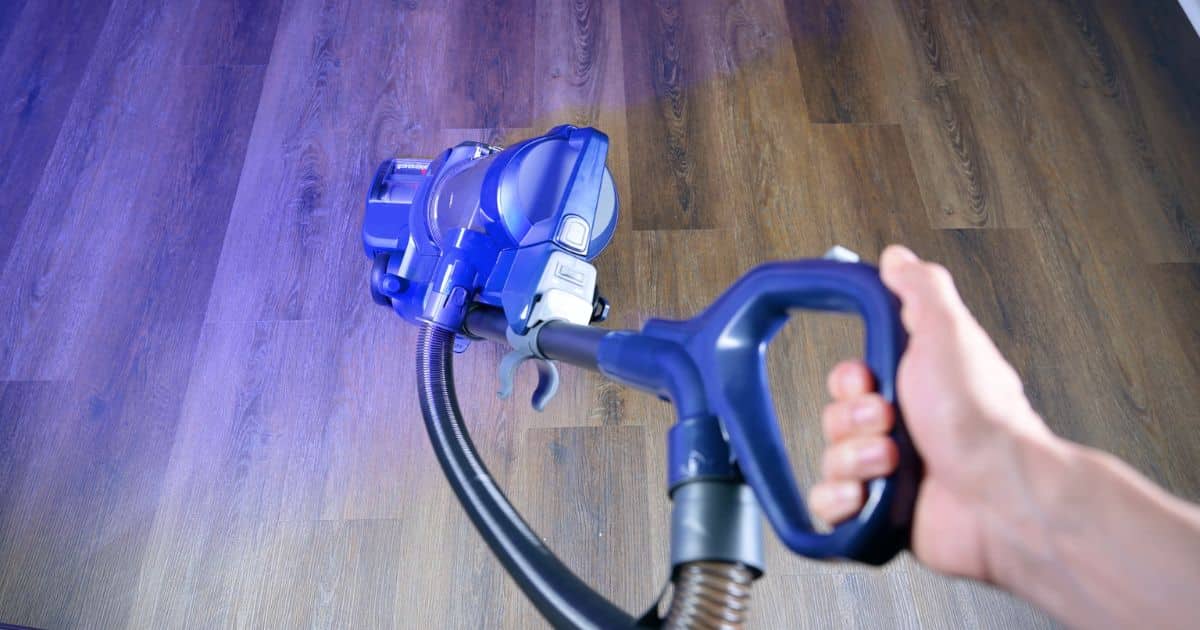 | Vacuum Wars Bissell Pet Hair Eraser DualBrush upright vacuum being steered across a hard floor, viewed from above.