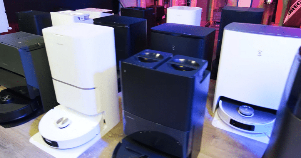 Conditional Approval Robots in Studio | Vacuum Wars Robot vacuums and self-empty docking stations in the Vacuum Wars testing studio, representing the types of products whose manufacturers must disclose detailed supply chain and manufacturing information when applying for FCC Conditional Approval.