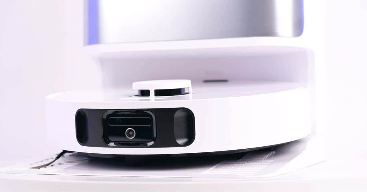 | Vacuum Wars Close-up of the Dreame D30 Ultra robot vacuum showing its top-mounted LiDAR sensor and front obstacle-avoidance sensors while docked.
