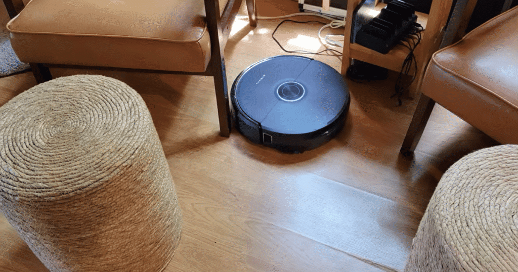 Narwal Flow 2 Home cables | Vacuum Wars Narwal Flow 2 robot vacuum navigating between furniture and nearby power cables on a hard floor during long-term home testing.