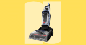 Bissell Revolution ExpressClean Plus Upright Carpet Cleaner 4499 | Vacuum Wars Bissell carpet cleaner with a transparent dirt tank and wheels, set against a bright yellow background.