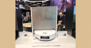 Dreame Aqua20 Pro Ultra Roller X Complete at IFA 2026 Title | Vacuum Wars Robotic vacuum cleaner on display at a trade show, labeled Aqua20 Pro Ultra Roller X Complete behind a brushed metal panel.