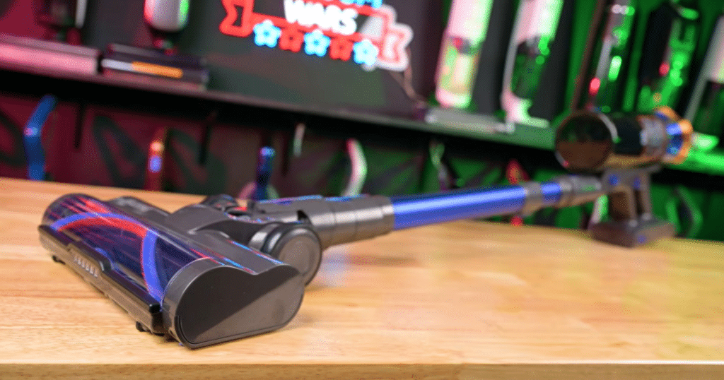 JellyPig X100 Cordless Stick Vacuum Cleaner at Vacuum Wars | Vacuum Wars JELLYPIG X100 cordless vacuum resting on a wooden table in the Vacuum Wars studio