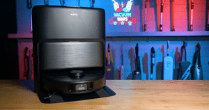 MOVA P70 Pro Ultra Robot Vacuum at the Vacuum Wars Studio Hero | Vacuum Wars Black robot vacuum on a wooden workbench in a workshop with tools hanging on a pegboard in the background