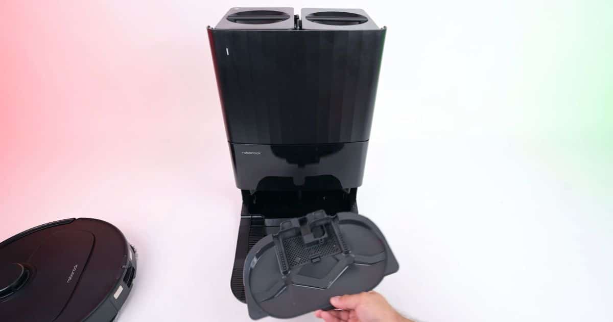 | Vacuum Wars Roborock Qrevo S Pro multifunction dock with the removable mop-washing tray being pulled out. The dock automatically empties the dustbin, washes and dries the mop pads, and refills the robot’s water tank.