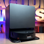 Roborock Saros 20 Flow in studio 150 | Vacuum Wars Black home video game console on a glass shelf with a colorful neon background.
