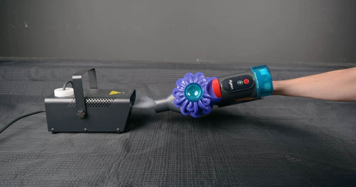 | Vacuum Wars A Dyson V10 Konical handheld vacuum undergoing a filtration test using a fog machine to check for visible particle leakage.