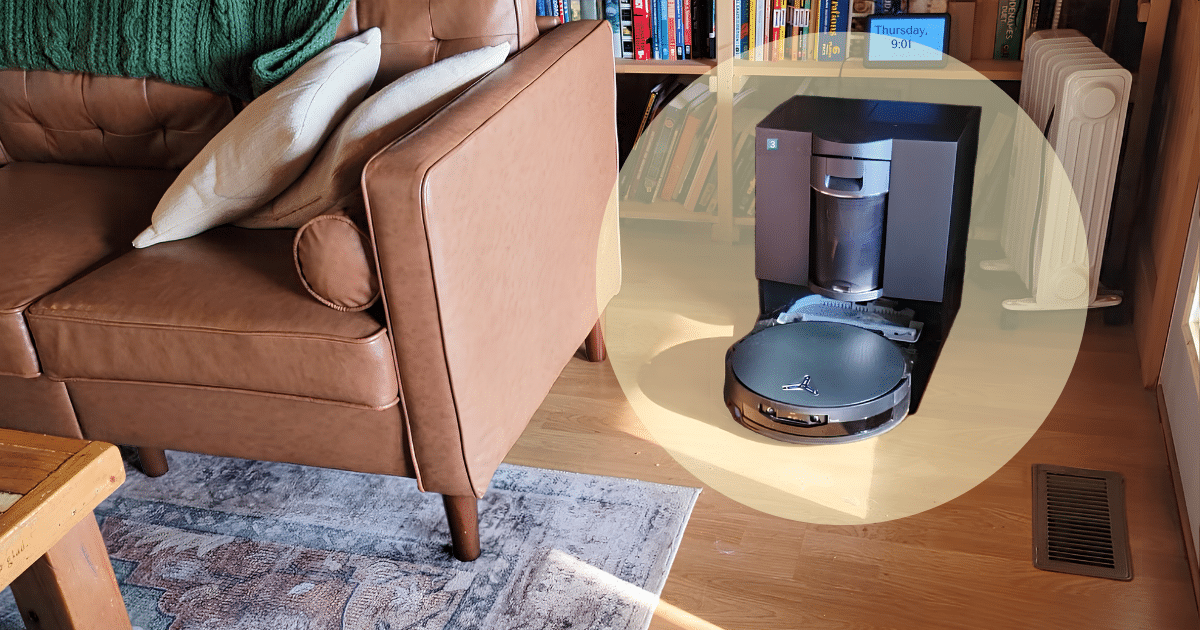 Ecovacs X12 at Home Vacuum Wars Review | Vacuum Wars Robot vacuum cleaner moving on a wooden floor beside a brown leather sofa in a living room.