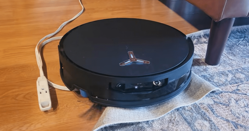 Ecovacs X12 at home Obstacle Avoidance Vacuum Wars | Vacuum Wars Ecovacs X12 OmniCyclone beside an extension cord at the edge of a rug during our home test.