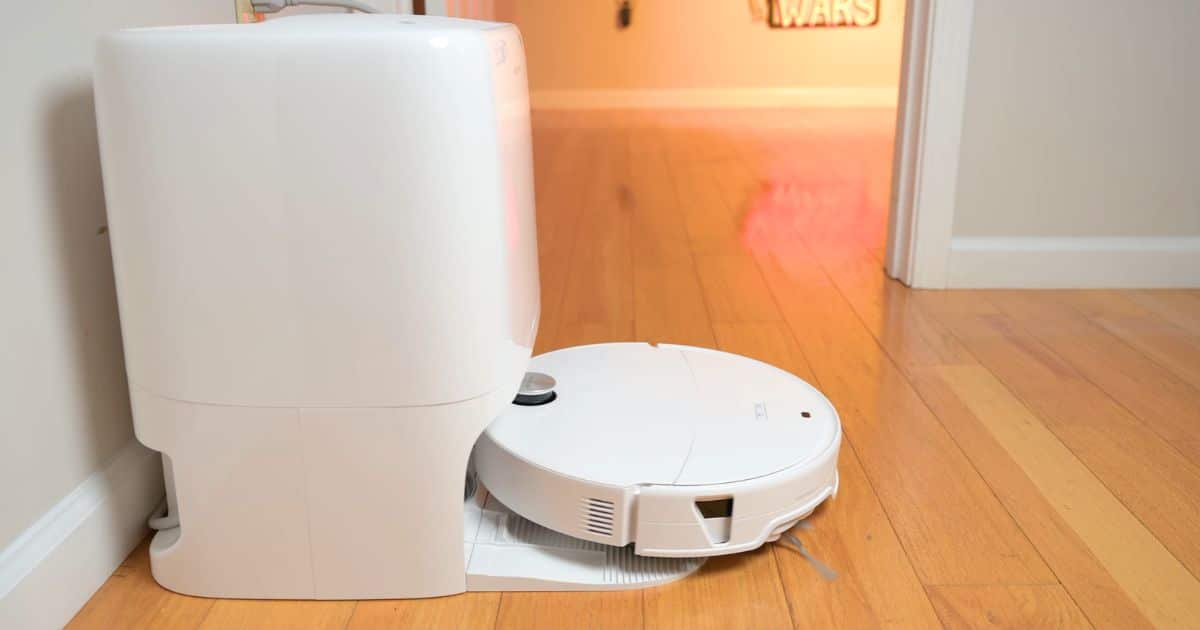| Vacuum Wars The white Roborock Qrevo Edge 3 Pro robot vacuum positioned at its multifunctional docking station on a hardwood floor in the Vacuum Wars testing studio.