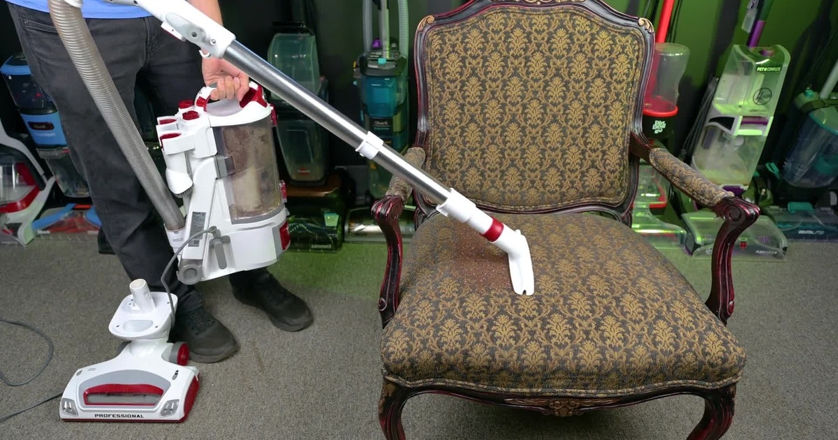 Shark NV501 Lift-Away Cleaning | Vacuum Wars Shark NV501 detached Lift-Away pod carried beside a chair while the wand cleans the seat.